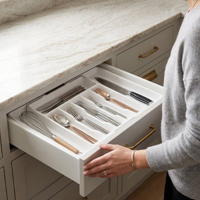 Range couvert blanc femme qui ferme le tiroir